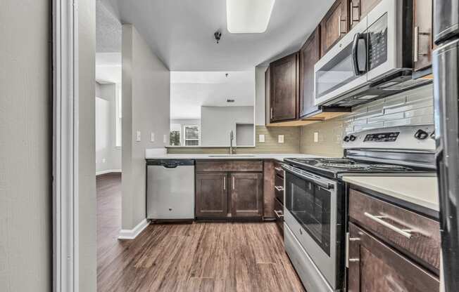 the kitchen of a rental house with a stove and a microwave