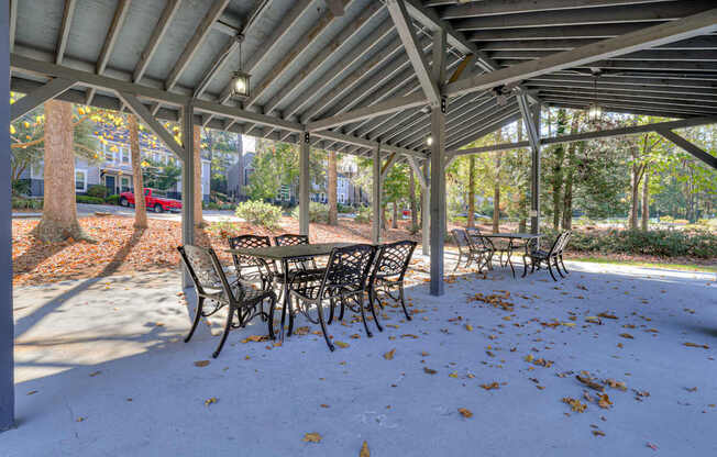 a covered patio with tables and chairs under a roof