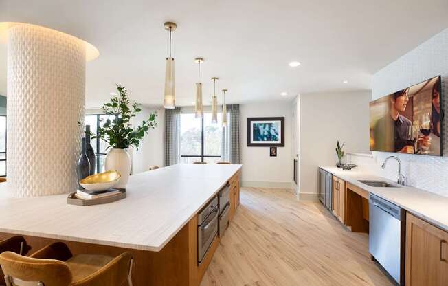 A modern kitchen with wooden floors and a white countertop.