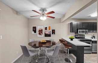 a dining room with a kitchen and a ceiling fan