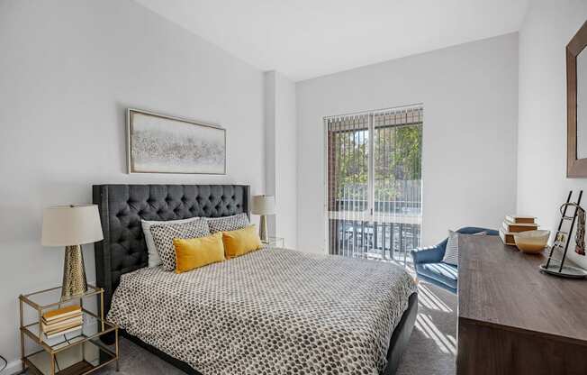 A bedroom with a large bed and a balcony.