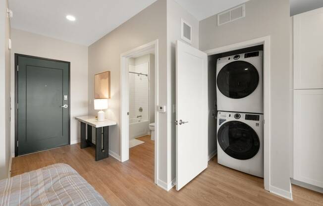 a bedroom with a washer and dryer in it and a bathroom with a