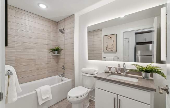 A bathroom with a white tub, toilet, and sink.