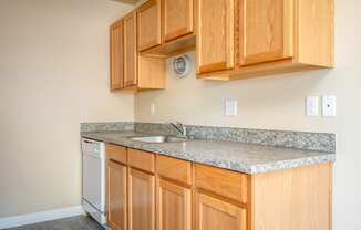 a kitchen with wood cabinets and granite counter top and a dishwasher