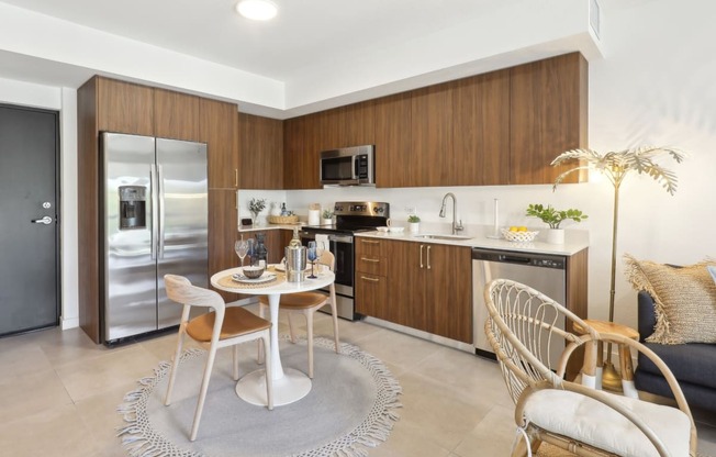 Kitchen in A1 Floor Plan with stainless steel appliances and a dining table at Westgate on University in Lauderhill, FL