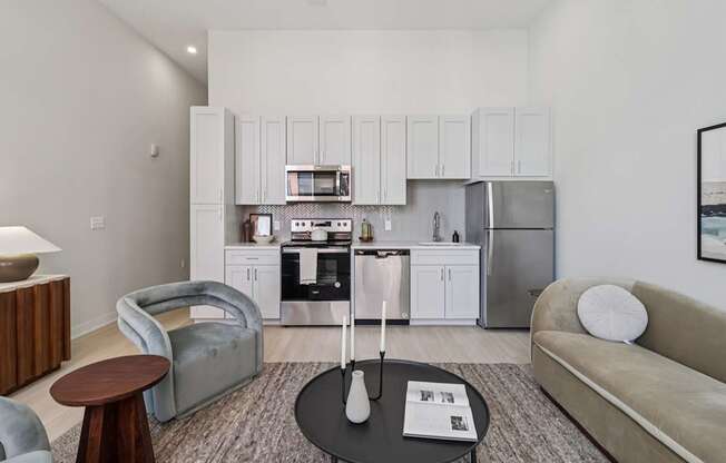 A modern kitchen with white cabinets and stainless steel appliances.
