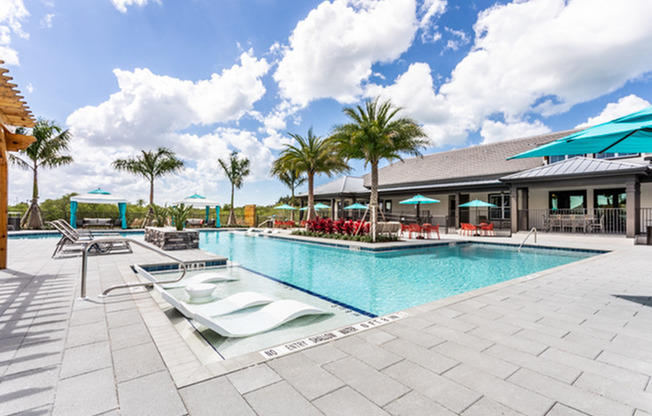 exterior pool with patio furniture and palm trees on sunny day