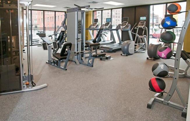 A gym with a variety of equipment including treadmills, weights, and exercise machines.