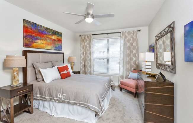Westwood Green Apartments Bedroom with wall to wall carpet, ceiling fan, and large window