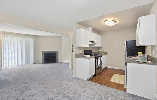 a living room with a fireplace and a kitchen