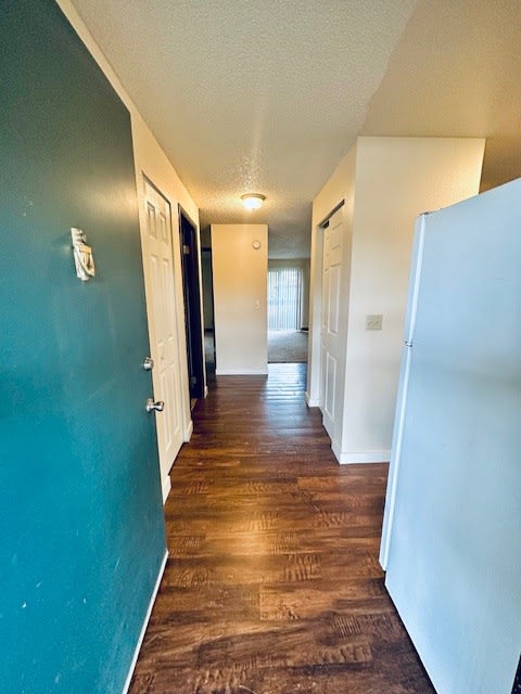 a hallway with a blue door  and a white door