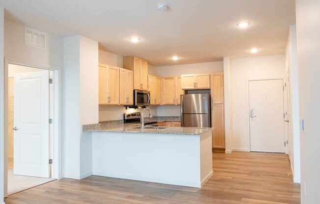 a kitchen with an island and a stainless steel refrigerator