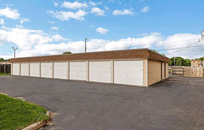 a large white garage with a brick roof on a driveway