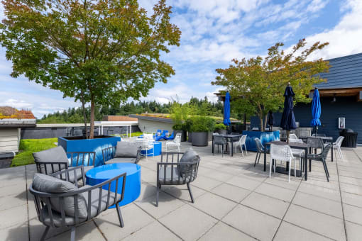 a patio with blue chairs and tables and umbrellas