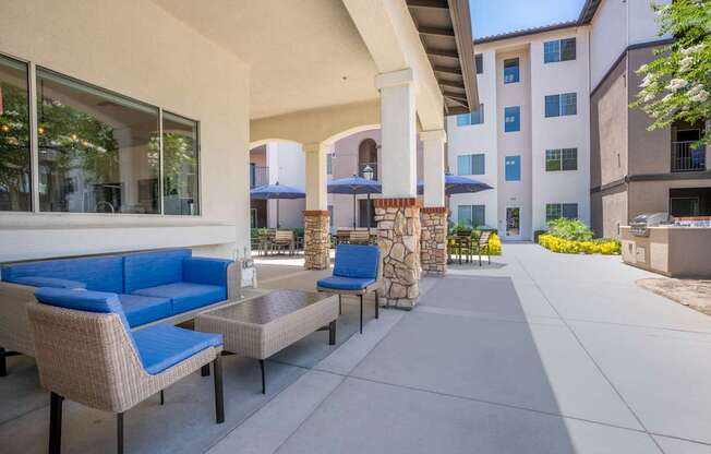 A patio with blue cushions and a table.