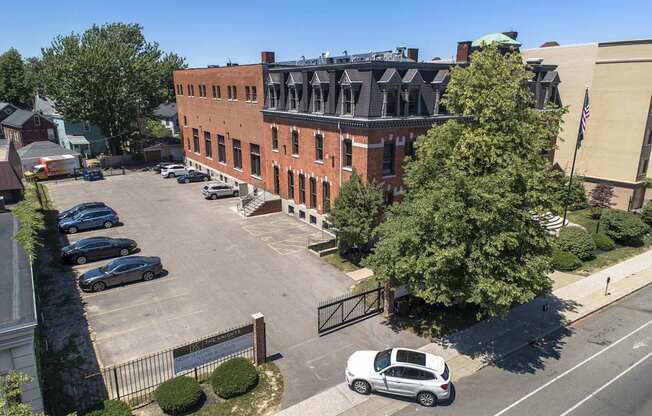 an aerial view of a brick building in a parking lot at The Knights @ 506 Delaware Apartments, New York