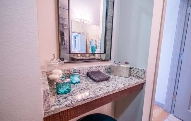 a bathroom with a granite counter top and a mirror