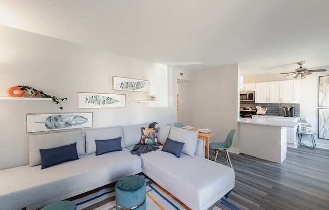 a living room with a couch and a table with a kitchen in the background