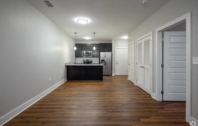 a kitchen and living room with wood floors and white closets