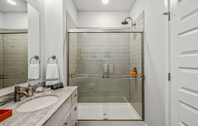 a bathroom with a shower and a sink and a mirror