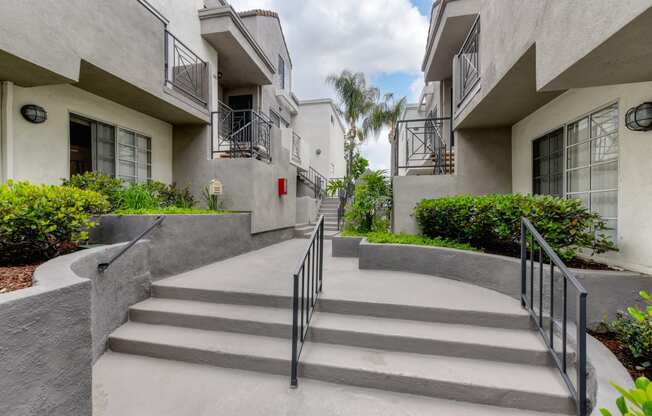 Long staircase area with only 3 steps leading to apartment entrances. 
