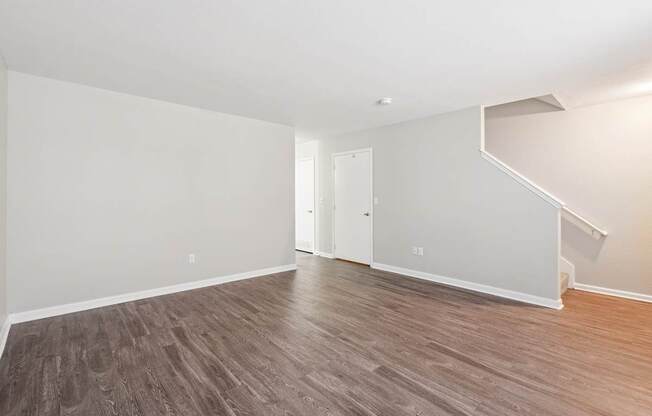 A room with wooden flooring and white walls.