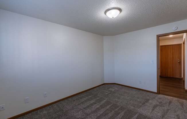 a bedroom with a door to the dining entry area. Fargo, ND Westwood Apartments