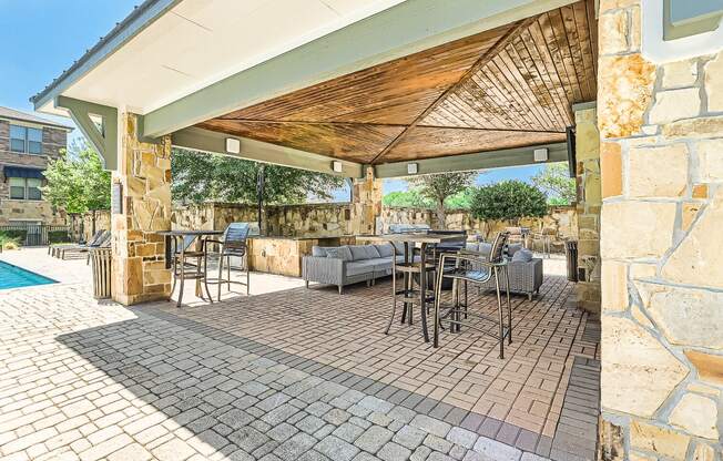a covered patio with tables and chairs and a pool at Discovery at Craig Ranch, McKinney