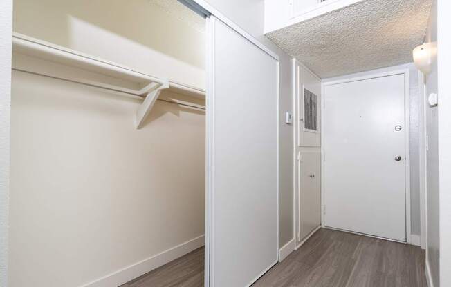 A white closet with a sliding door and a white door.