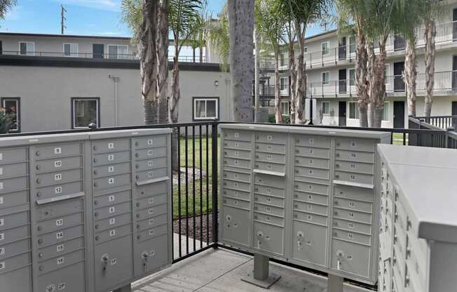 A metal mailbox is on the left and right side of a gate.