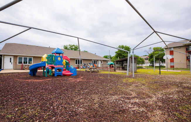 a playground with a play set in front of a building at Sutton Hill Apartments, Des Moines, IOWA