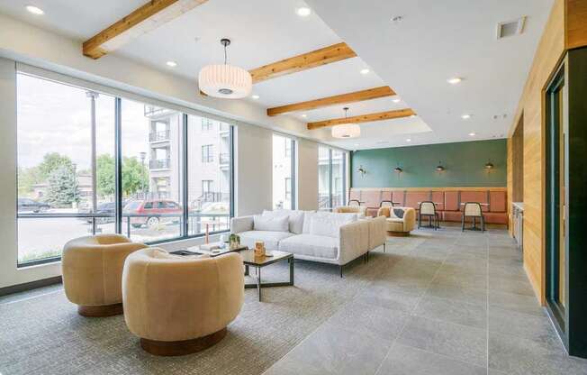 a modern, cafe-style lounge with armchairs, couches, tables and chair, and a coffee bar