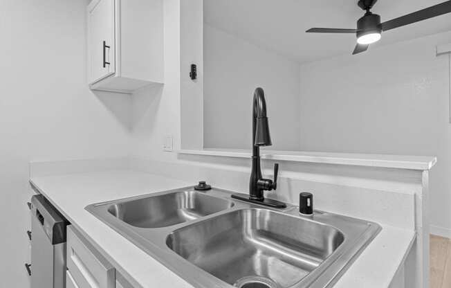 the kitchen of our studio apartment atrium with stainless steel sink and white countertops