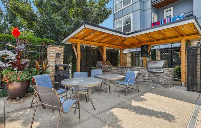 a patio with tables and chairs and a grill