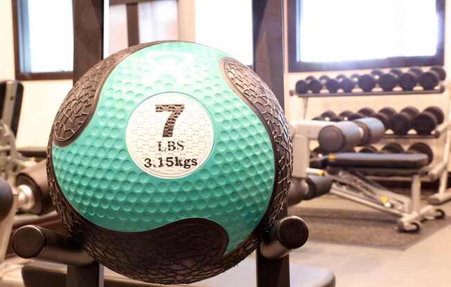 A green and black weighted ball with the number 7 on it.