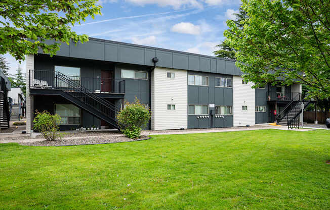 A modern apartment building with a green lawn in front.