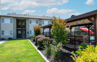 View of courtyard area with exterior of building with lush landscaping next to gated community pool