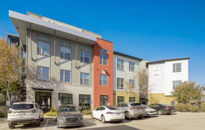 an apartment building with cars parked in front of it