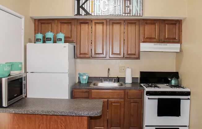 a kitchen with wood cabinets and white appliances