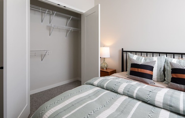 A bedroom with a bed, pillows, and a lamp.