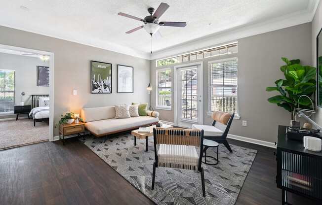 living room with patio door and large windows  at Sugarloaf Crossings Apartments in Lawrenceville, GA 30046