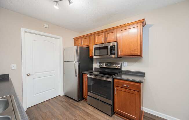 a kitchen with black appliances and wooden cabinets and a refrigerator