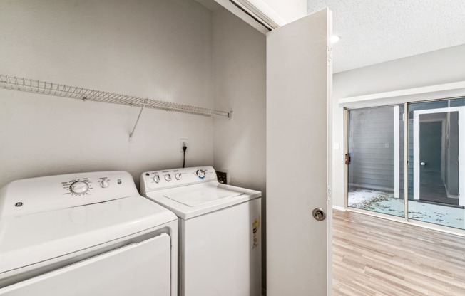 the spacious laundry room with two washers and dryers and a sliding glass door