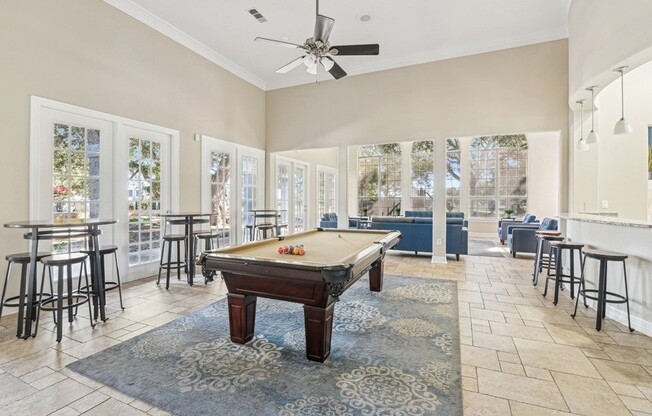 a game room with a pool table and a bunch of chairs