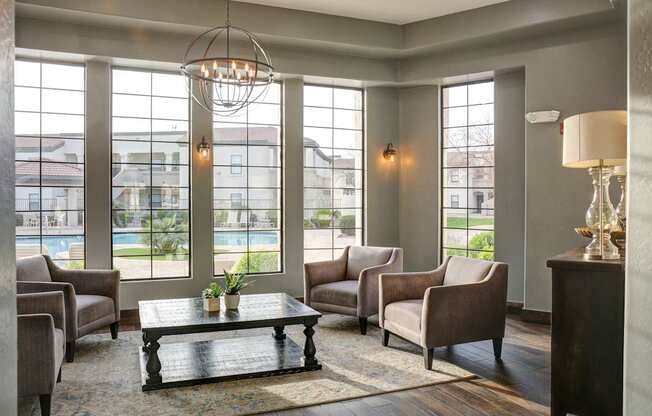 A living room with a large window and a view of a pool and houses.