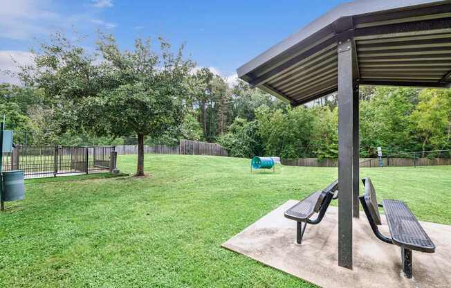 A park with a picnic table and benches.
