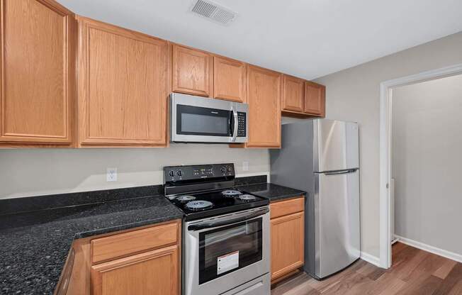 A kitchen with wooden cabinets and a black countertop.