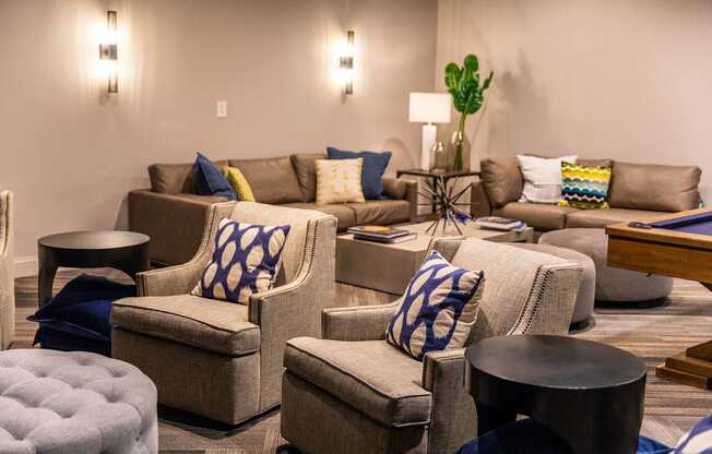 A living room with a brown couch and blue and yellow pillows.