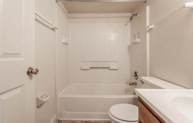 a bathroom with a tub and a sink and a toilet