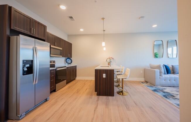 a kitchen and living room with stainless steel appliances and a table and chairs